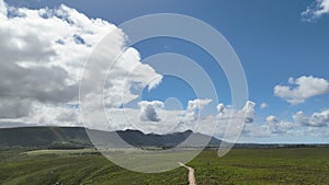 Aerial view of landscape with hills and clouds in distance