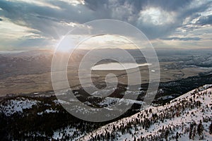 Aerial view landscape with a Lake and snow covered mountains at sunrise with a dramatic sky.