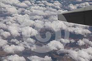 Aerial view landscape. Landscape trough airplane window with clouds and part of an airplane wing
