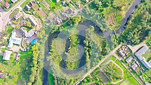 Aerial view landscape of winding small river among the small town, stream in green field