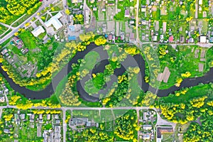 Aerial view landscape of winding small river among the small town, stream in green field