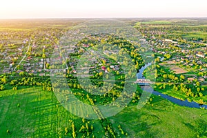 Aerial view landscape of winding small river among the small town, stream in green field meadow, top view