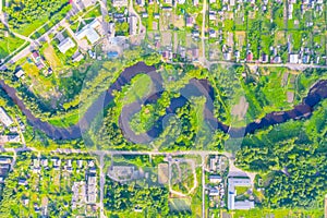 Aerial view landscape of winding small river among the small town, stream in green field, top view meadow