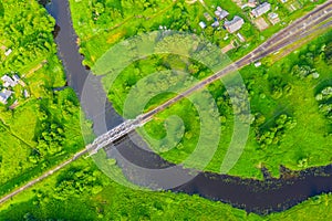 Aerial view landscape of winding small river among the small town, stream in green field, top view meadow