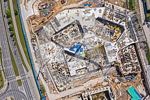 Aerial view of large building site in city with many construction equipment and materials