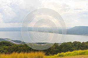 Aerial view of a large dam, mountains, and road