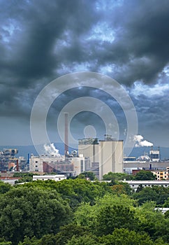 Aerial view of large factory with chimneys emitting smoke into the environment