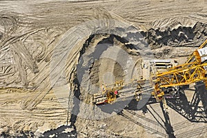 Aerial view of large heavy equipment machine mining natural resource. Coal mining by bucket wheel excavator. Heavy