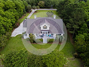 Aerial view of large home with on wooded grassy property