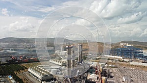 Aerial view of large industrial gas power plant in countryside. Top view. Complex with pipelines and chimneys