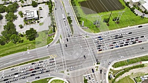 Aerial view of large multilane road intersection with traffic lights and moving cars and trucks