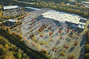 Aerial view of large parking lot in front of rgocery store with many parked colorful cars. Carpark at supercenter
