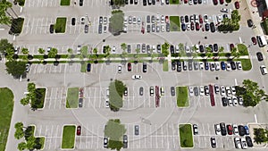 Aerial view of large parking lot with many parked colorful cars. Carpark at supercenter shopping mall with lines and