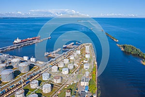 Aerial view large port oil loading terminal with large storage tanks. Railway infrastructure for the delivery of bulk cargo and