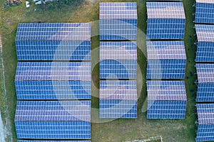 Aerial view of large sustainable electrical power plant with rows of solar photovoltaic panels for producing clean