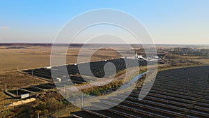 Aerial view of large sustainable electrical power plant with rows of solar photovoltaic panels for producing clean