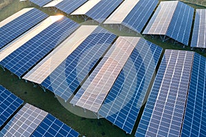 Aerial view of large sustainable electrical power plant with rows of solar photovoltaic panels for producing clean