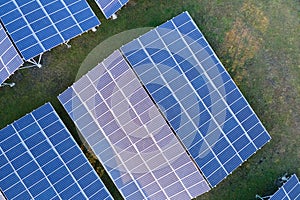 Aerial view of large sustainable electrical power plant with rows of solar photovoltaic panels for producing clean