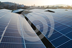 Aerial view of large sustainable electrical power plant with rows of solar photovoltaic panels for producing clean