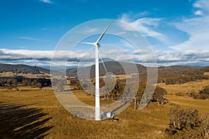 Aerial view of a large three blade industrial wind turbine generating electricity