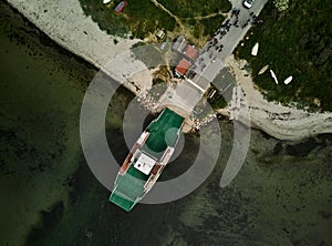 Aerial view of a large vessel docked in a port, with a body of water in the background