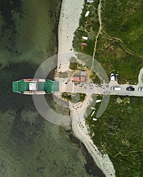 Aerial view of a large vessel docked in a port, with a body of water in the background