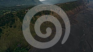 Aerial view lava field cracked stone structure with mountain and village countryside valley panorama