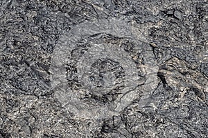 Aerial view of lava field;, pahoehoe lava. Swirled texure and patterns, silver metallic color, cracks in surface.
