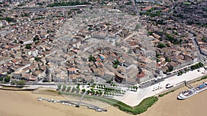 Aerial view of Libourne cityscape on banks of Dordogne river overlooking Gothic spire of Church of St. John Baptist