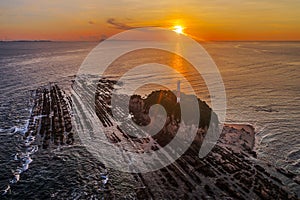 Aerial view of lighthouse covered with rocks at sunrise in Malaysia