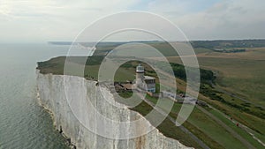 Aerial view of the lighthouse on the edge of a cliff next to the sea.