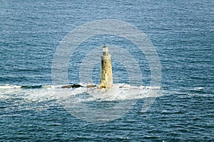 Aerial view of lighthouse at sea surrounded by water on Maine coastline, south of Portland