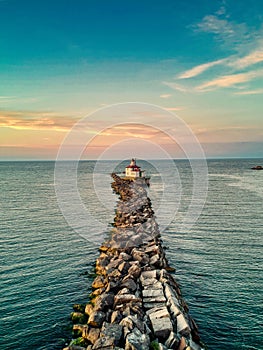 Aerial view of lighthouse surrounded by water in  Ashtabula during sunset