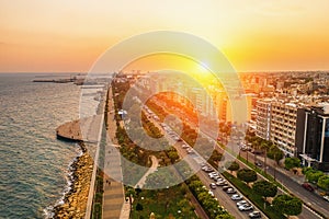 Aerial view of Limassol city coast in Cyprus. Walk path Molos Park with palm trees, Mediterranean sea and urban skyline