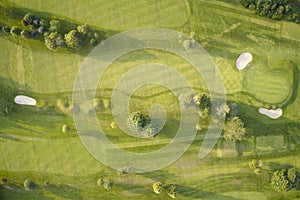 Aerial view of links golf course during summer showing green and bunkers at driving range