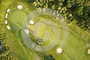 Aerial view of links golf course during summer showing green and bunkers at driving range