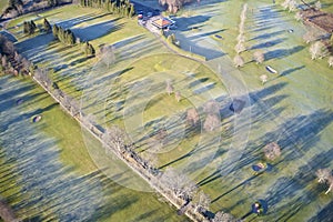 Aerial view of links golf course during summer showing green and bunkers at driving range club house