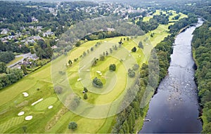 Aerial view of links golf course during summer showing green and bunkers at driving range