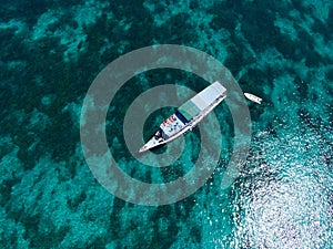 Aerial view of a liveaboard boat in turquoise waters in Pink beach, Komodo, Indonesia