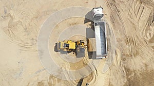 Aerial view loading bulldozer in open air quarry. Sand mining industry. Bulldozer machine. Crawler bulldozer moving at sand mine.