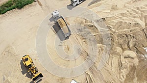 Aerial view loading bulldozer in open air quarry. Sand mining industry. Bulldozer machine. Crawler bulldozer moving at sand mine.