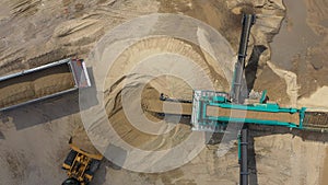 Aerial view loading bulldozer in open air quarry. Sand mining industry. Bulldozer machine. Crawler bulldozer moving at sand mine.