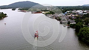 aerial view of local fishing boat cursing along coast back from ocean to shore.