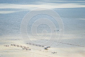 Aerial view of local fishing boat and traditional fish trap with wooden floating house in the Songkhla Lake.