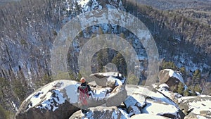 Aerial view of a lone male climber on a snowy mountain top.