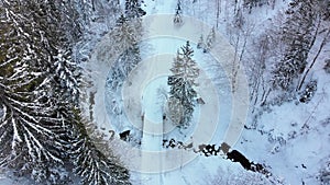 Aerial view on Lonely Car Riding on Snowy Road in Magic Winter Forest