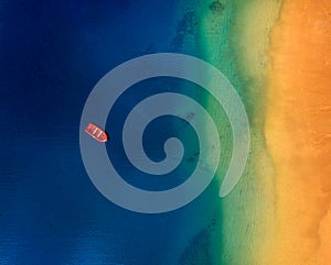 Aerial view of a lonely red boat anchored off the coast of Las Teresitas beach. Tenerife, Canaries, Spain