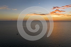 Aerial view of lonesome white yacht at sunset floating on sea waves with ripple surface. Motor boat recreation on ocean