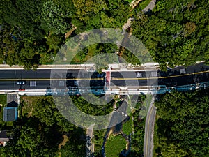 an aerial view of a long train crossing a bridge in the country side