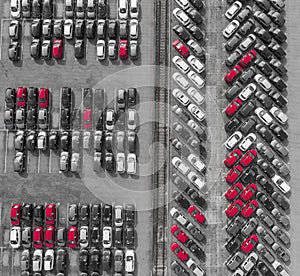 Aerial view lot of vehicles on parking for new car. Black and White selective red colour.